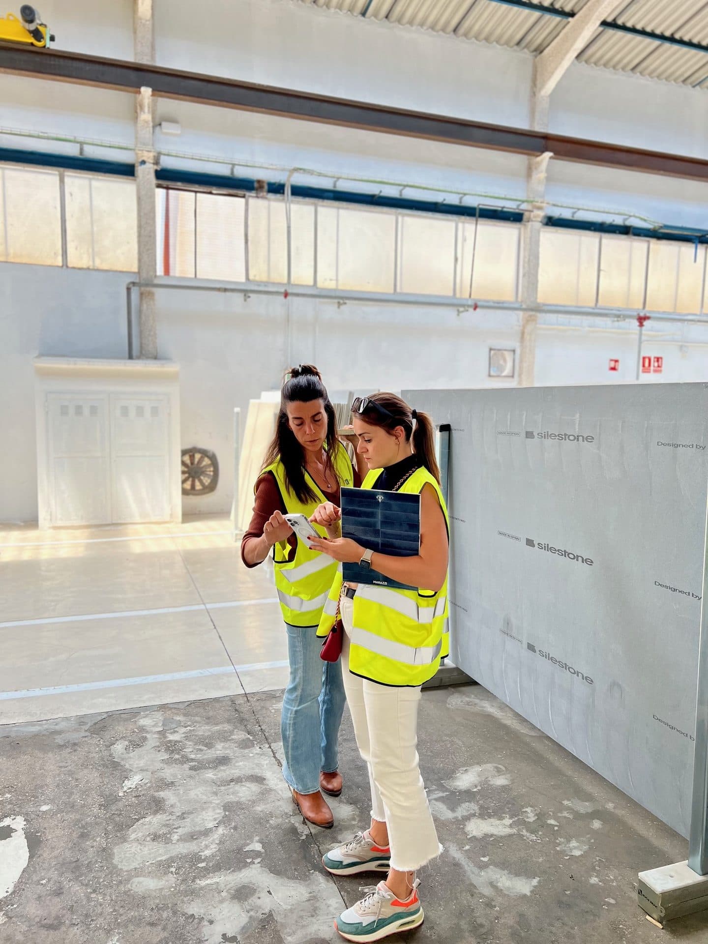 Two people in hi-vis vests inspecting material panels on site